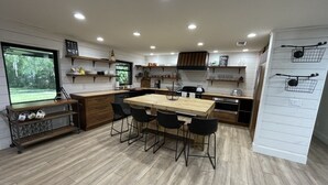 Una cocina moderna con una mesa de comedor de madera, sillas negras y electrodomésticos integrados.