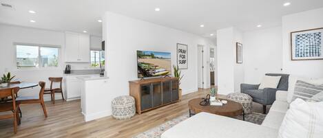 A modern living room with a grey sofa, a coffee table, and a patterned rug.