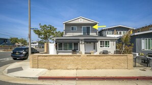 A two-story house with a balcony, a garage, and a driveway.
