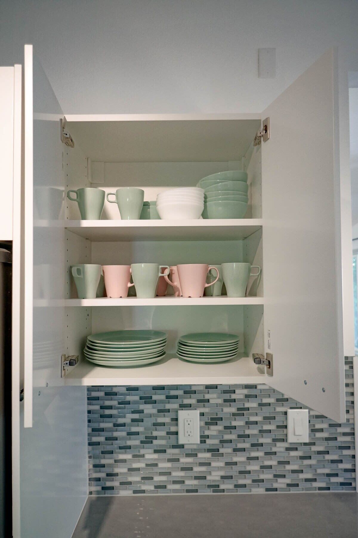 Un mueble de cocina con estantes que contienen platos y tazas.