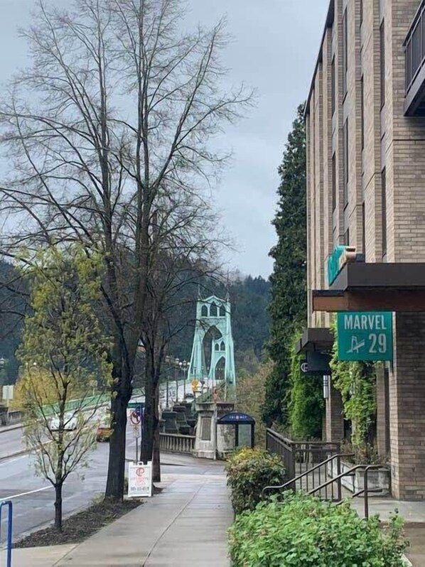 A street view with a green sign reading "Marvel Ave 29" and a bridge in the background.
