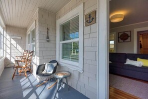 Relax in a cozy seating area with a sofa and chairs, featuring a nautical-themed anchor decoration and a welcome sign.