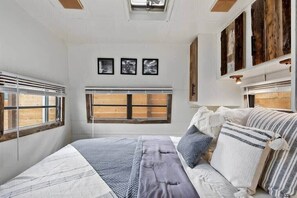 Une chambre à coucher avec un lit, une fenêtre et un puits de lumière.