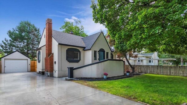 A single-story house with a brick chimney, a garage, and a well-maintained lawn. - #StayinMyDistrict Twin Falls Pendleton Chic Suite (Twin Falls)