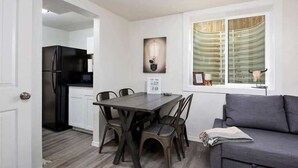 A compact living space with a dining area, kitchenette, and a sofa. - #StayinMyDistrict Twin Falls Pendleton Chic Suite (Twin Falls)