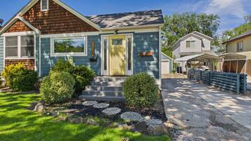 A two-story house with a front porch, a garage, and a well-maintained lawn.