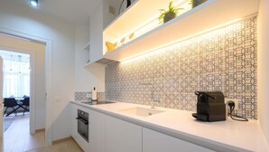 A modern kitchen with white cabinetry, a built-in oven, a sink, and a coffee machine. - Stylish apartment in Middelkerke - 200m from the beach (Middelkerke)