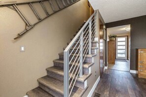 A staircase with a metal railing, wooden steps, and a dark floor. - #StayInMyDistrict Eclectic Boise Townhouse near St. Als (Boise)
