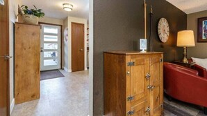 A hallway with a wooden door, a red armchair, and a clock on the wall. - #StayInMyDistrict Eclectic Boise Townhouse near St. Als (Boise)