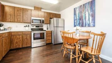 Enjoy cooking in this well-equipped kitchen with a dining table for four, microwave, oven, and refrigerator.
