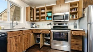 A kitchen with wooden cabinets, a built-in microwave, a double oven, and a refrigerator. - #StayInMyDistrict Cozy Central Boise Townhouse (Boise)
