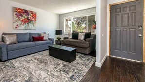 A living room with two sofas, a coffee table, and a painting on the wall. - #StayInMyDistrict Cozy Central Boise Townhouse (Boise)