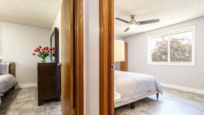 A bedroom with a bed, a dresser, a mirror, and a window. - #StayInMyDistrict Cozy Central Boise Townhouse (Boise)