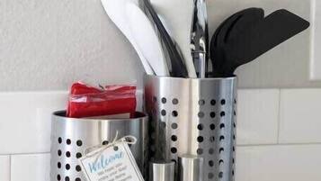 A kitchen utensil holder with a 'Welcome' sign and a 'Stay in my District' sign.