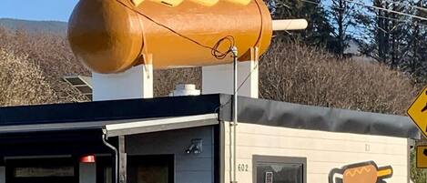 Un edificio con un gran letrero de hot dogs en la pared, una entrada pequeña y el número 602 en la puerta.