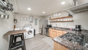 A modern kitchen with stainless steel appliances, wooden countertops, and a built-in stove.
