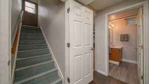 A staircase leading to a room with a wooden floor and a white door.