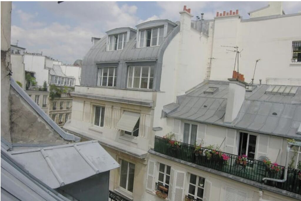 Une rangée de bâtiments de style européen, dotés de toits à pignon et de lucarnes.