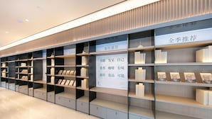 A modern library interior with bookshelves, a display of books, and promotional posters. - Ji Hotel (Binzhou)