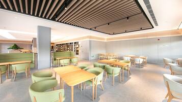 A modern library with green seating, wooden tables, and bookshelves.