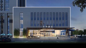 A modern hotel with a large glass facade, a prominent entrance, and a parking area in front. - Ji Hotel (Binzhou)