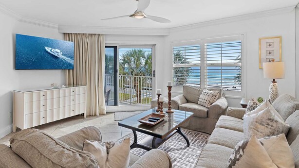 A living room with a sofa set, a coffee table, a TV mounted on the wall, and a balcony with a view of the ocean. - Repeat Guest Favorite Maravilla 2304    2Bed/2Bath Gulf front, Pet Friendly, Beach Service (Miramar Beach)