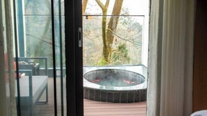 A room with a glass door leading to an outdoor hot tub area. - Thinking Land Lingyan Forest Hotel (Dujiangyan)