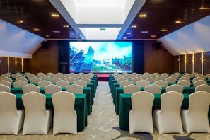 A conference room with rows of chairs and a large screen at the front. - Thinking Land Lingyan Forest Hotel (Dujiangyan)