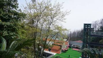 Un barrio residencial con un césped verde, un edificio de techo rojo y una estructura alta al fondo.