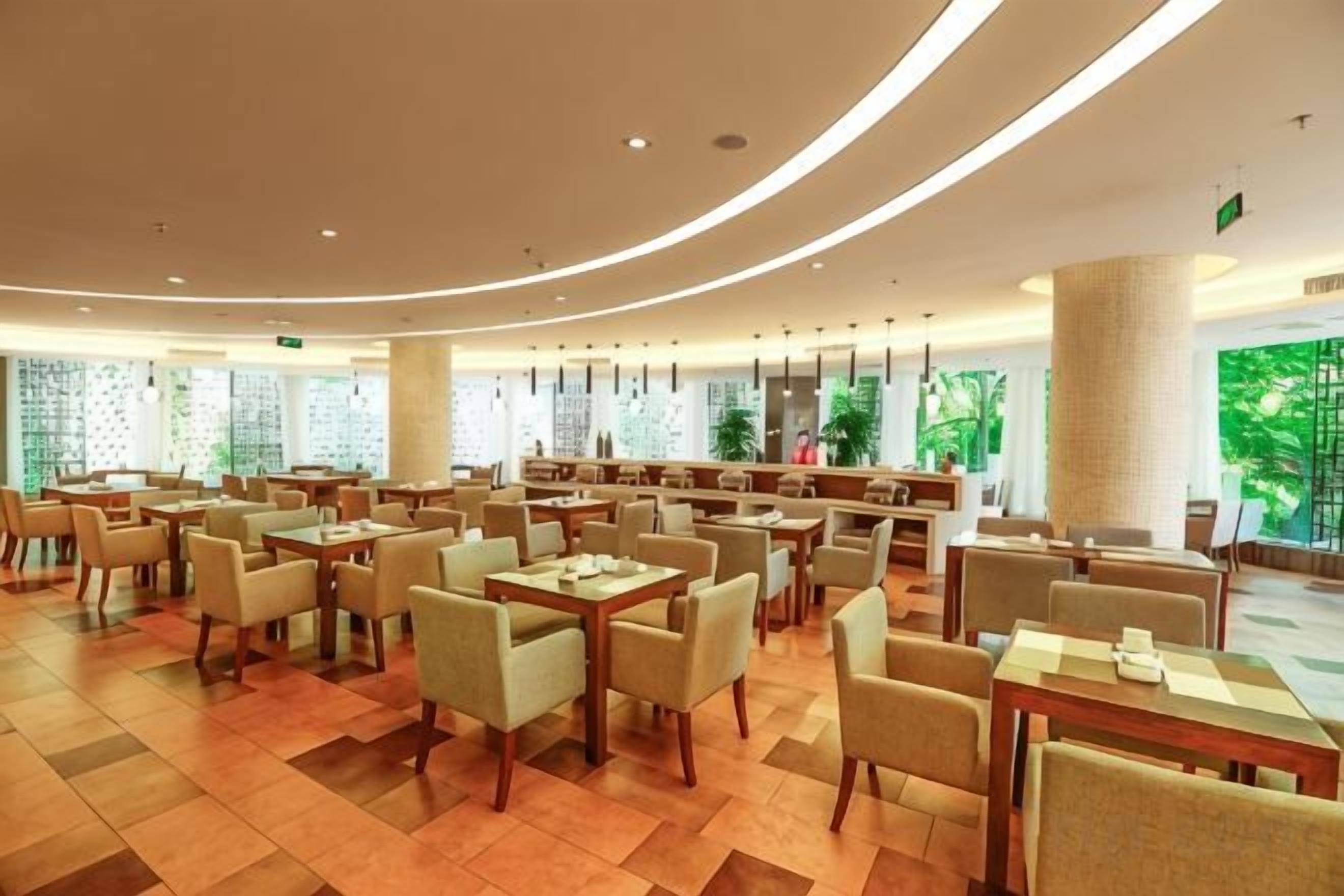 A spacious indoor area with multiple seating arrangements, including tables and chairs, and a central counter area.
