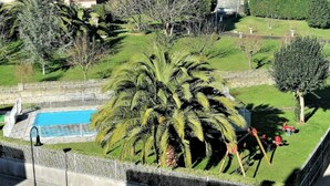Ein Wohngebiet mit Schwimmbad, umgeben von üppiger Vegetation und Palmen.