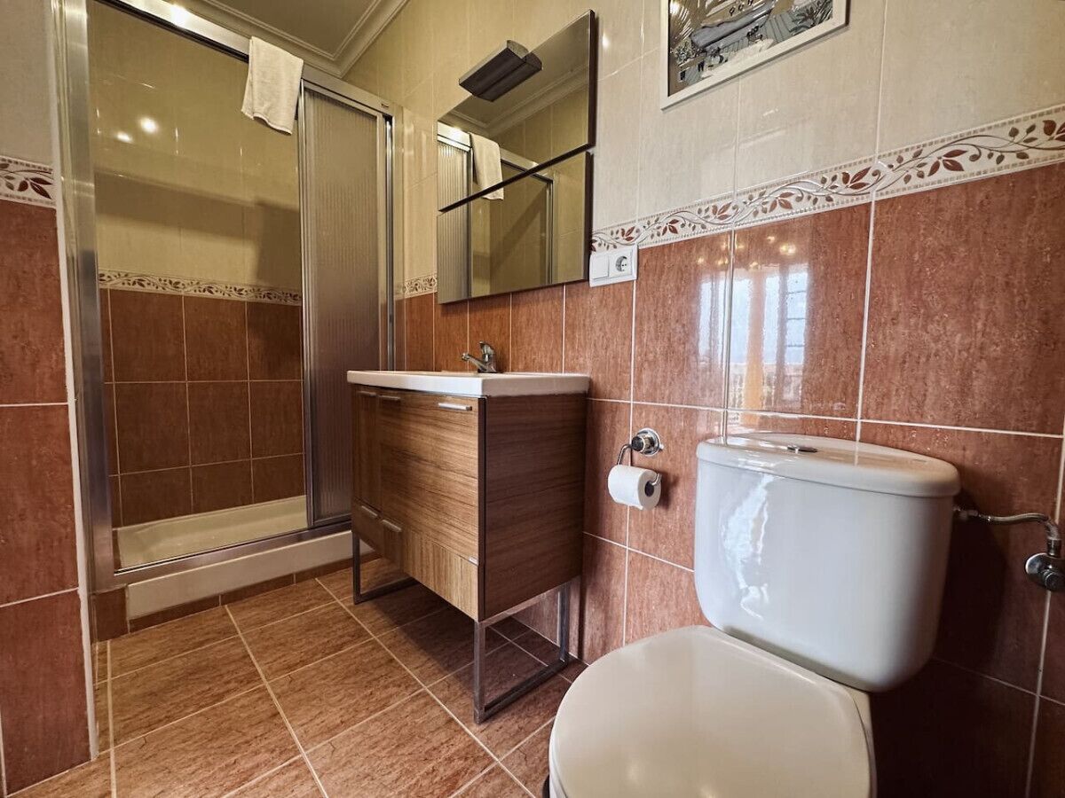 A bathroom with a shower, toilet, and sink.