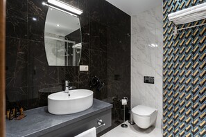 Luxe tweepersoonskamer | Badkamer | Een douche, gratis toiletartikelen, een haardroger, pantoffels