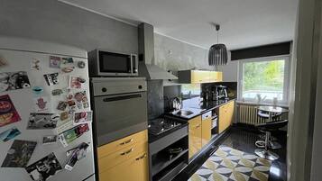 Cocina moderna con refrigerador, microondas, estufa y lavamanos.