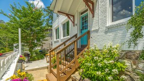 A white brick house with a wooden staircase leading to a blue door. - WALK to top Chattanooga action from this Fun Fabulous Family/Friend(ly) Home! (Chattanooga)