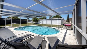 Piscina exterior coberta com espreguiçadeiras e banheira de hidromassagem.