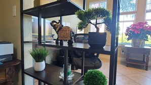 Una libreria nera a più livelli con oggetti decorativi e piante in vaso.