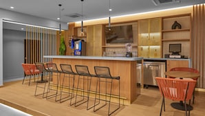 Una cocina moderna con barra, armarios de madera y taburetes de bar.