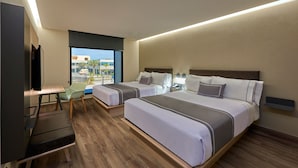 Una habitación de hotel con dos camas, un escritorio, una silla y un televisor.