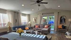 A spacious living room with a dining area, a ceiling fan, and a view to the outside. - This house is a 4 bedroom(s), 2 bathrooms, located in Eagle Point, OR. (Eagle Point)