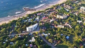 An aerial view of a coastal area with a beach, buildings, and greenery. - PERFECT LUXURY stay steps to the ocean, amazing food, and lots of live music!  (Tamarindo)