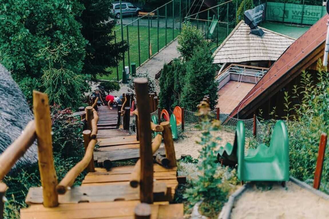 A wooden bridge leading to a building with a sloped roof.
