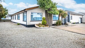 A modern two-story house with a gravel driveway and a small garden area. - Port Tara Holiday Home, close to Portballintrae Harbour and the Giant's Causeway (Portballintrae, Bushmills)
