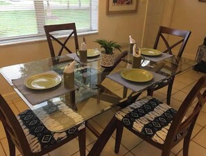 Enjoy meals in this cozy dining area with a glass table and comfortable seating for four.