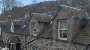 Un edificio de piedra con múltiples ventanas y techo inclinado.