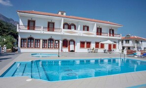 Una piscina al aire libre de temporada, sombrillas, tumbonas