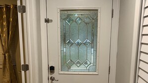 Una porta bianca con un vetro e una maniglia in metallo.
