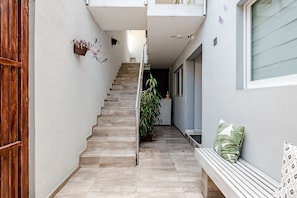 Staircase corridor with a bench and potted plant.