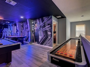 Enjoy games and entertainment in this stylish room featuring a pool table and foosball table.