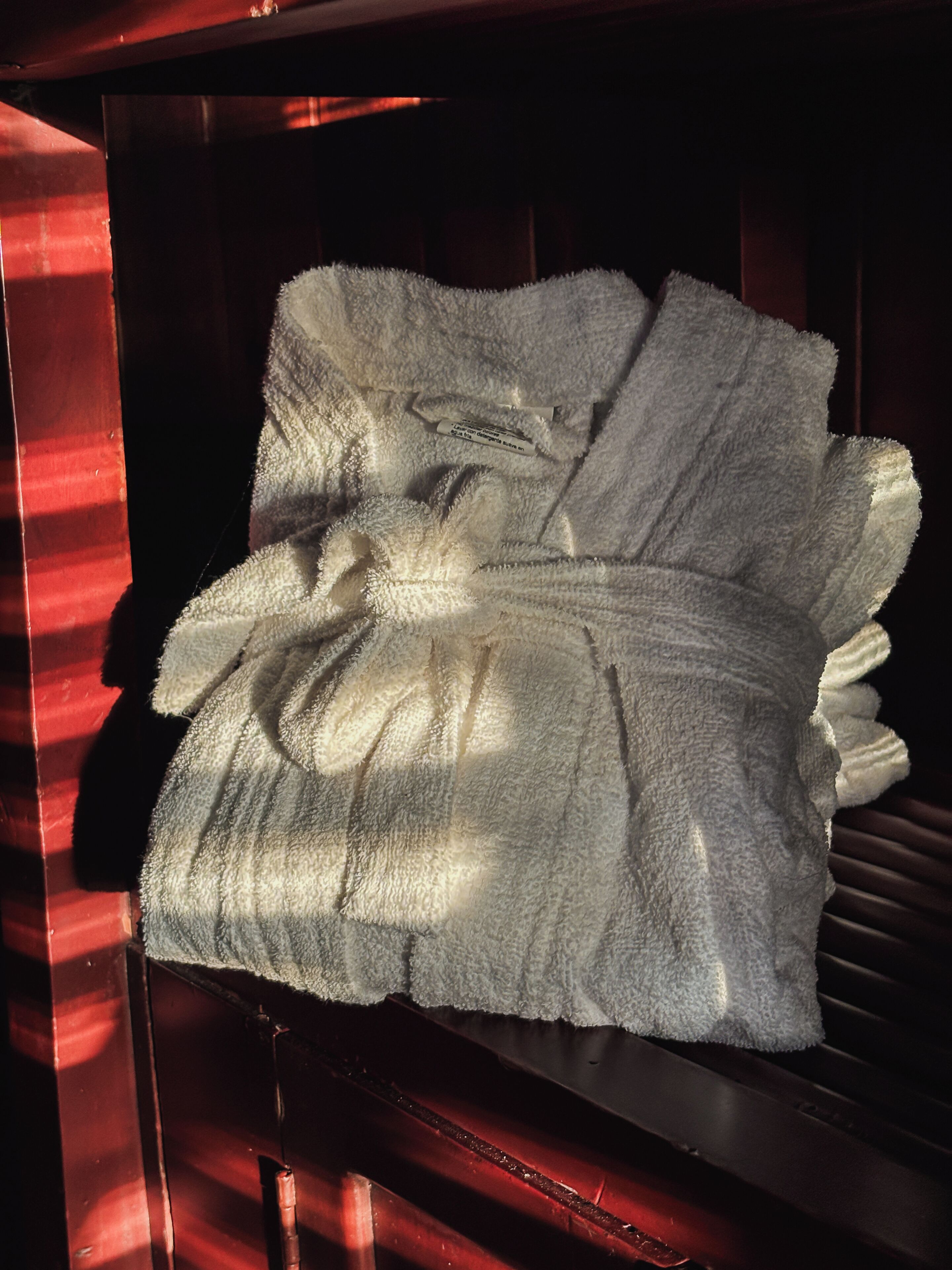 A folded white towel on a wooden surface.